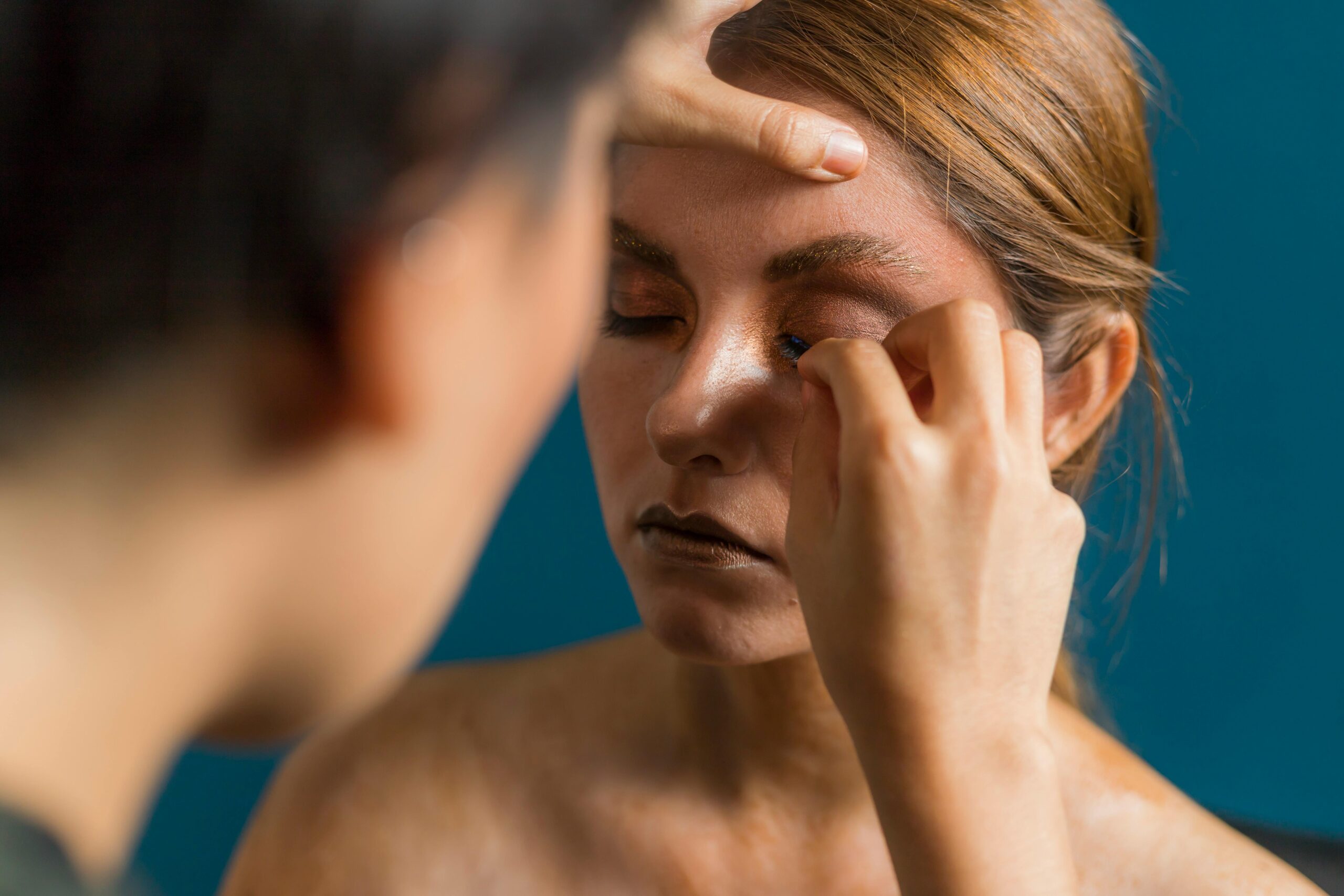 Maquilleuse professionnelle appliquant un maquillage à une future mariée entourée de ses amies lors d’un atelier beauté EVJF à Arcachon.