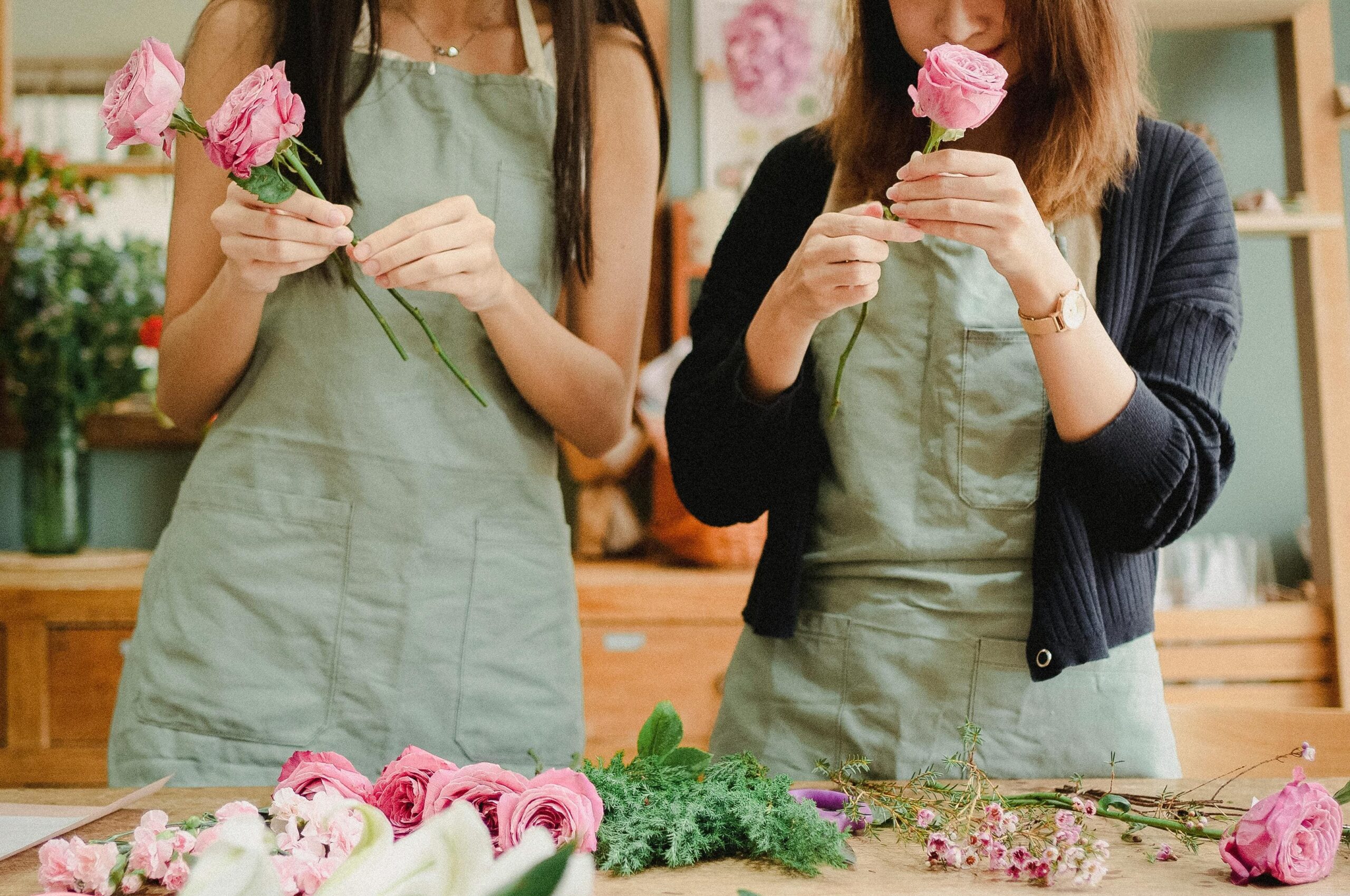 Mains de femmes en train de créer des couronnes de fleurs lors d’un atelier EVJF à Lyon.