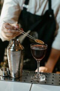 Barman en pleine création d’un cocktail sophistiqué durant un atelier EVJF à Biarritz"