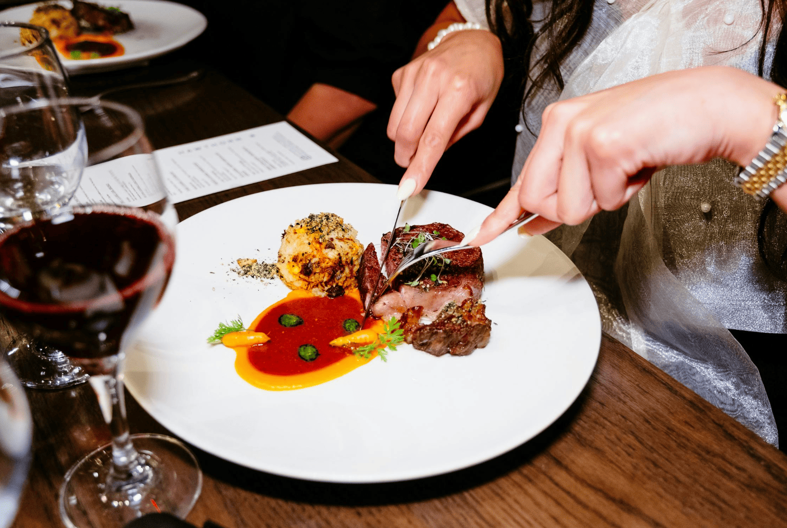 Des convives partagent un dîner élégant dans un lieu secret à Strasbourg, à la lumière tamisée, dans une ambiance intime et raffinée.