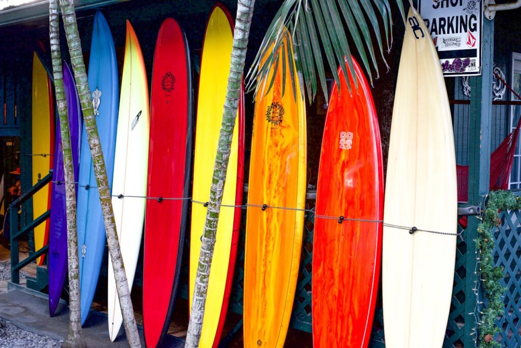 Rangée de planches de surf colorées prêtes pour une initiation à Biarritz
