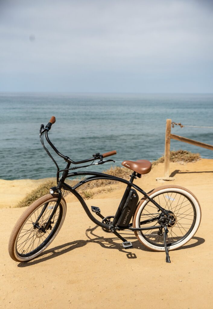 Vélo électrique noir stationné en bord de mer sur un sentier côtier à Biarritz, activité EVJF originale