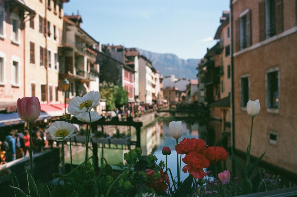 Vue pittoresque de la ville d’Annecy avec ses canaux, ses ruelles animées et les montagnes en arrière-plan.