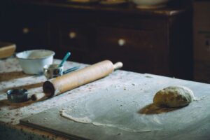 Plan de travail avec rouleau, pâte à pétrir et ustensiles pendant un atelier pâtisserie EVJF à Marseille