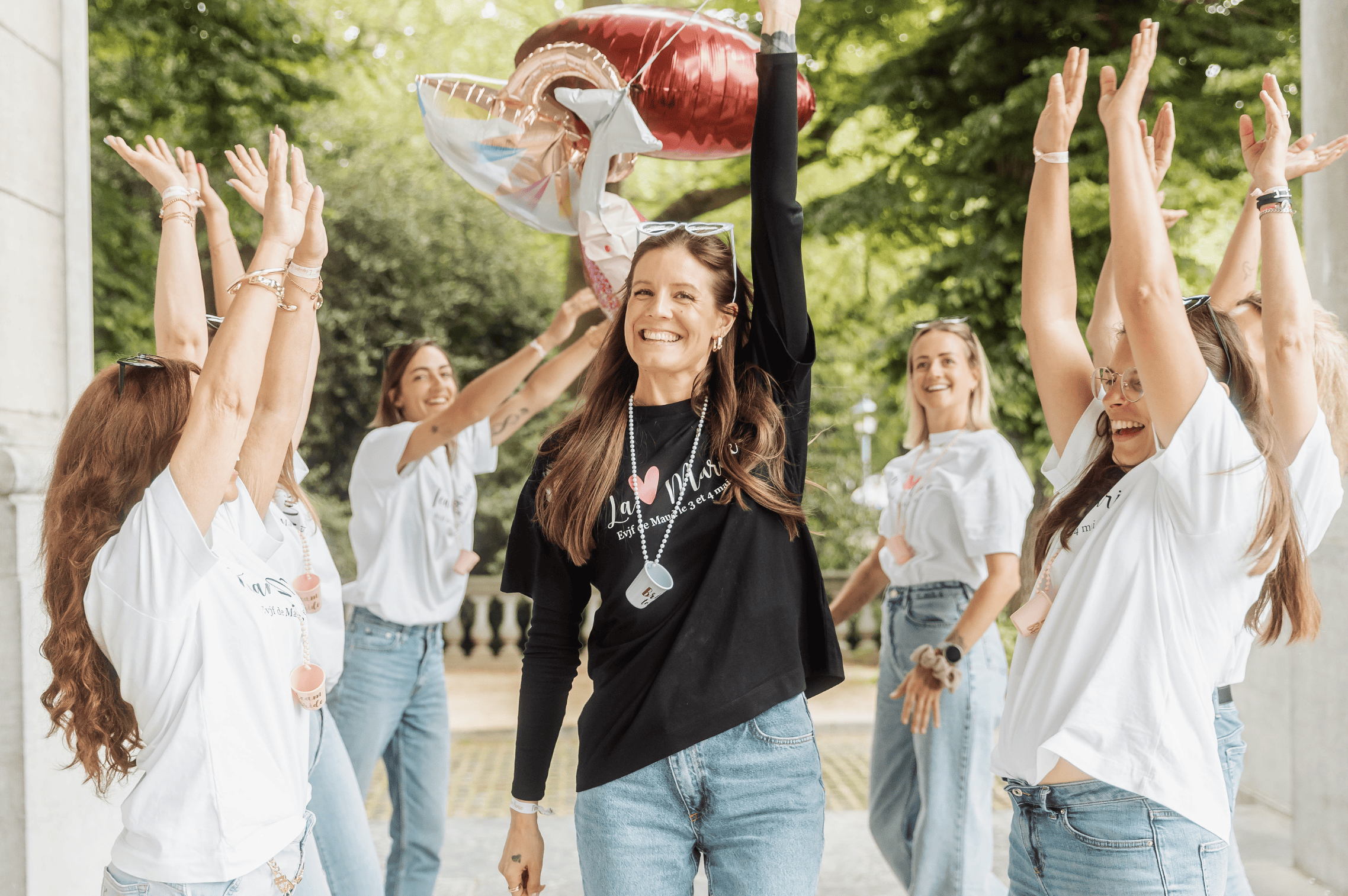 Participants à un EVJF à Bruxelles immortalisées pendant un shooting photo, rires et mouvements naturels dans un décor urbain