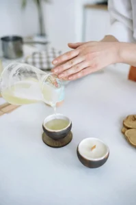 Coulage de cire chaude dans un récipient en céramique lors d’un atelier bougie à Lyon