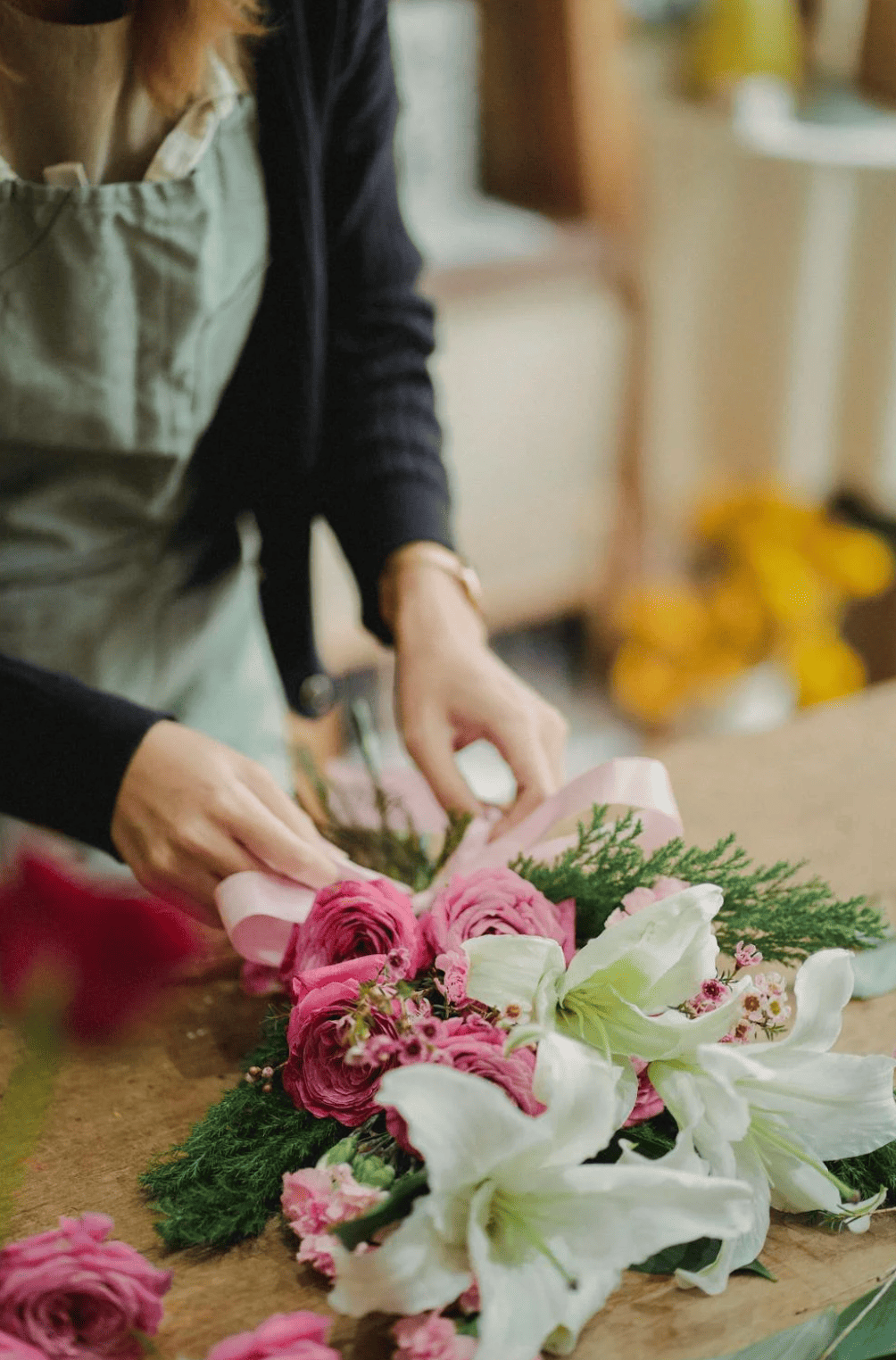 Femme concentrée pendant un atelier EVJF à Bruxelles, en train de créer un bouquet de fleurs avec soin
