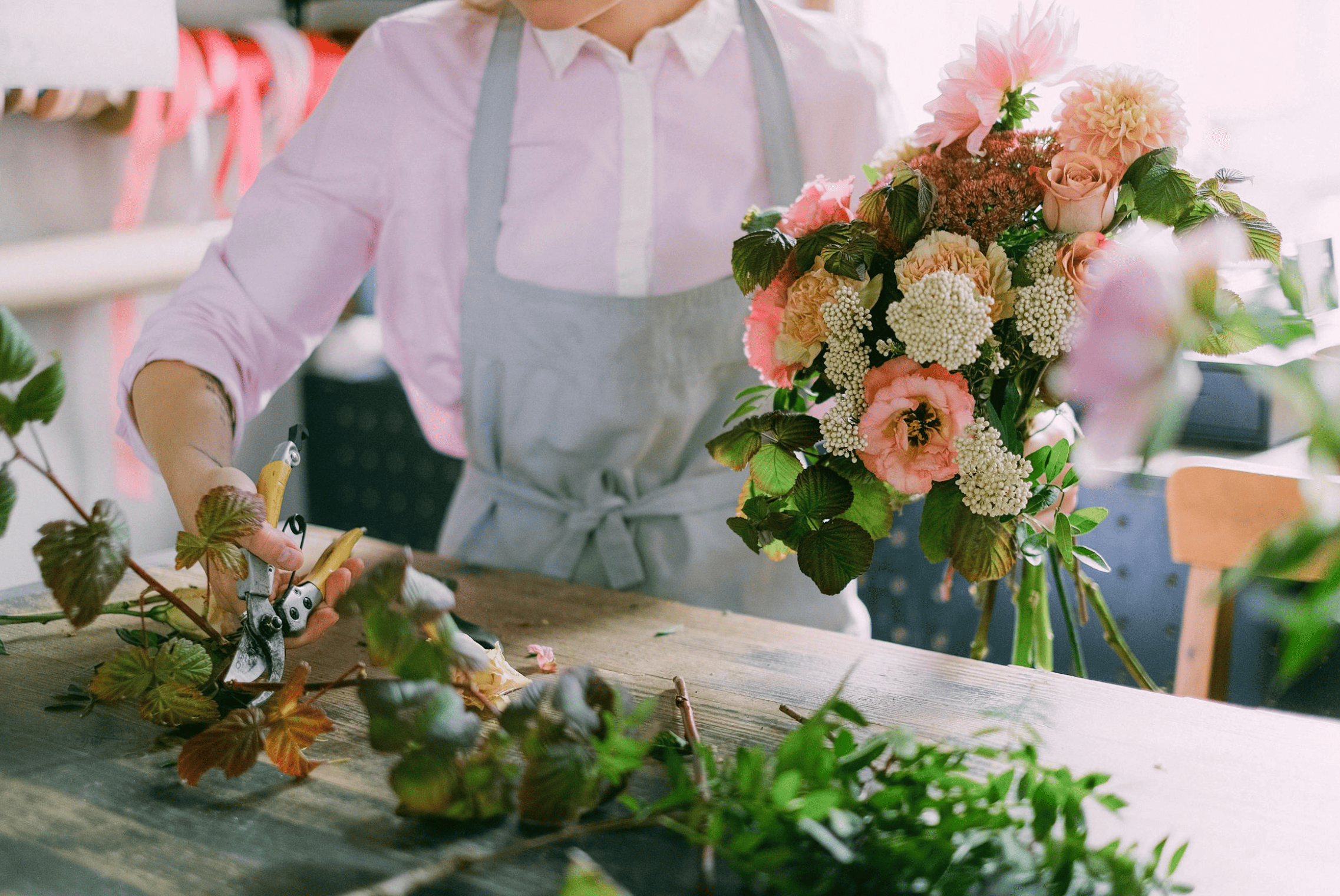 Participant à un atelier EVJF à Bruxelles en train de disposer des fleurs pour composer un bouquet personnalisé