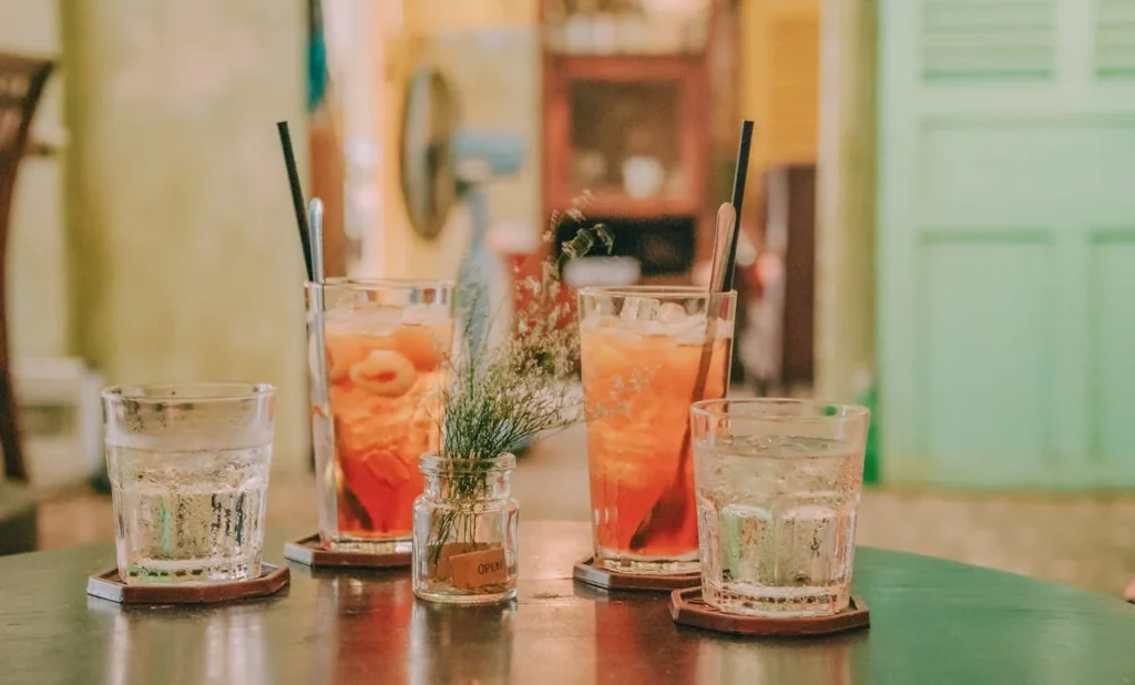 Table de bar avec cocktails colorés et verres d’eau pendant un atelier cocktails à Paris.