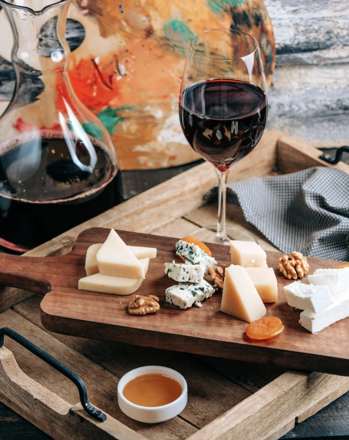 Planche de fromages variés avec noix et abricots secs, accompagnée d’un verre de vin rouge lors d’un atelier à Lyon.