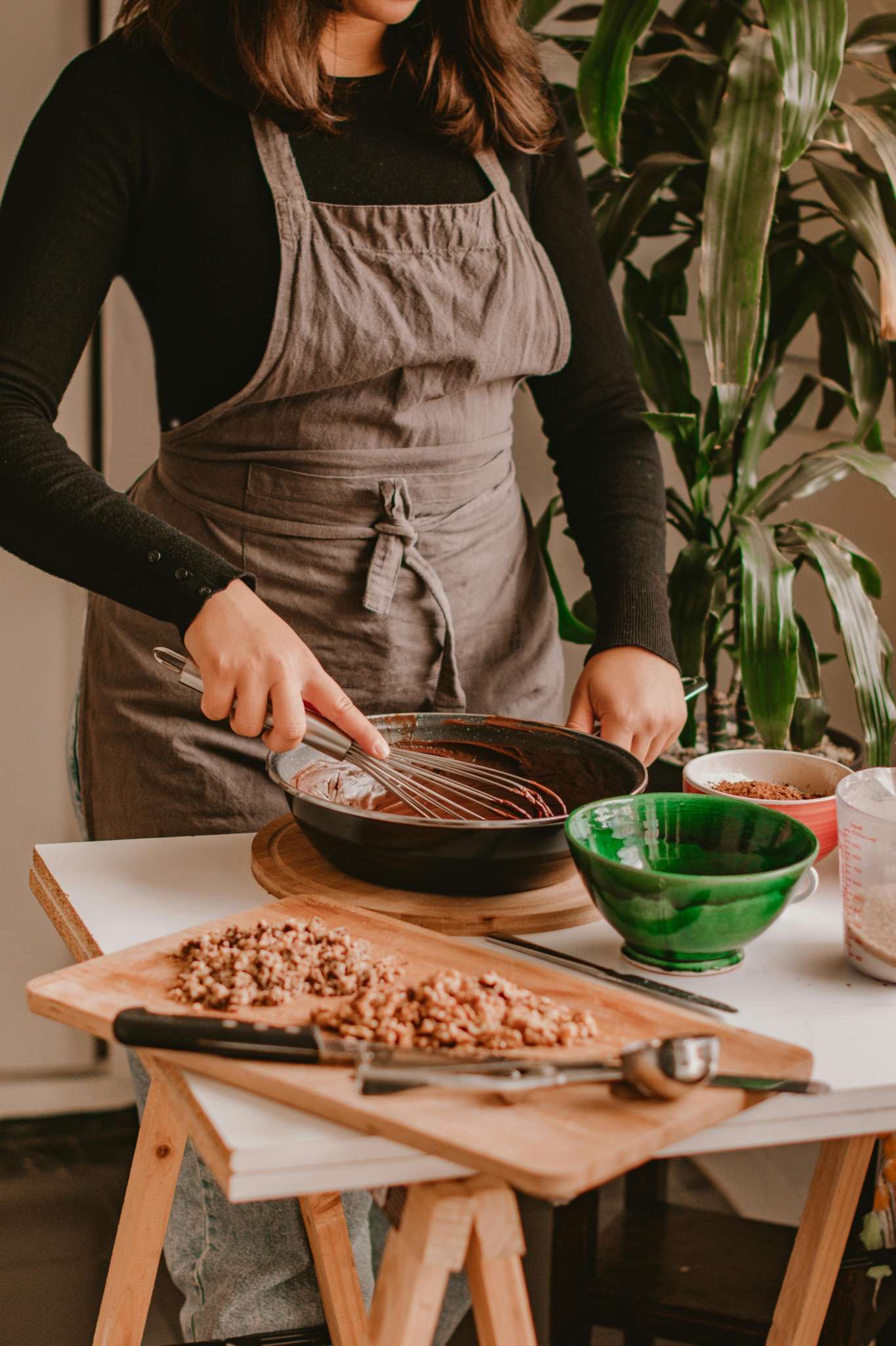Jeune femme en tablier fouettant une préparation chocolatée lors d’un atelier pâtisserie EVJF à Marseille
