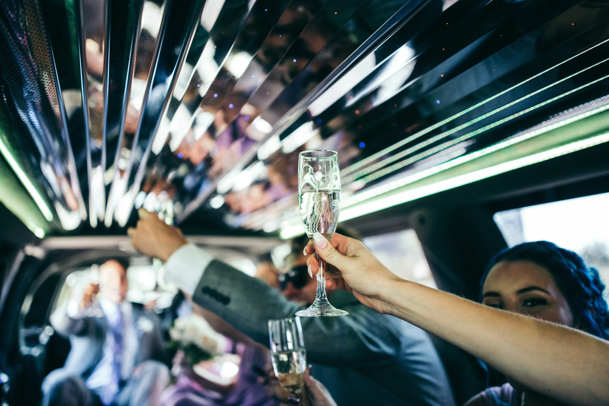 Groupe de femmes qui trinquent avec du Champagne dans une limousine lors d’un EVJF à Marseille.