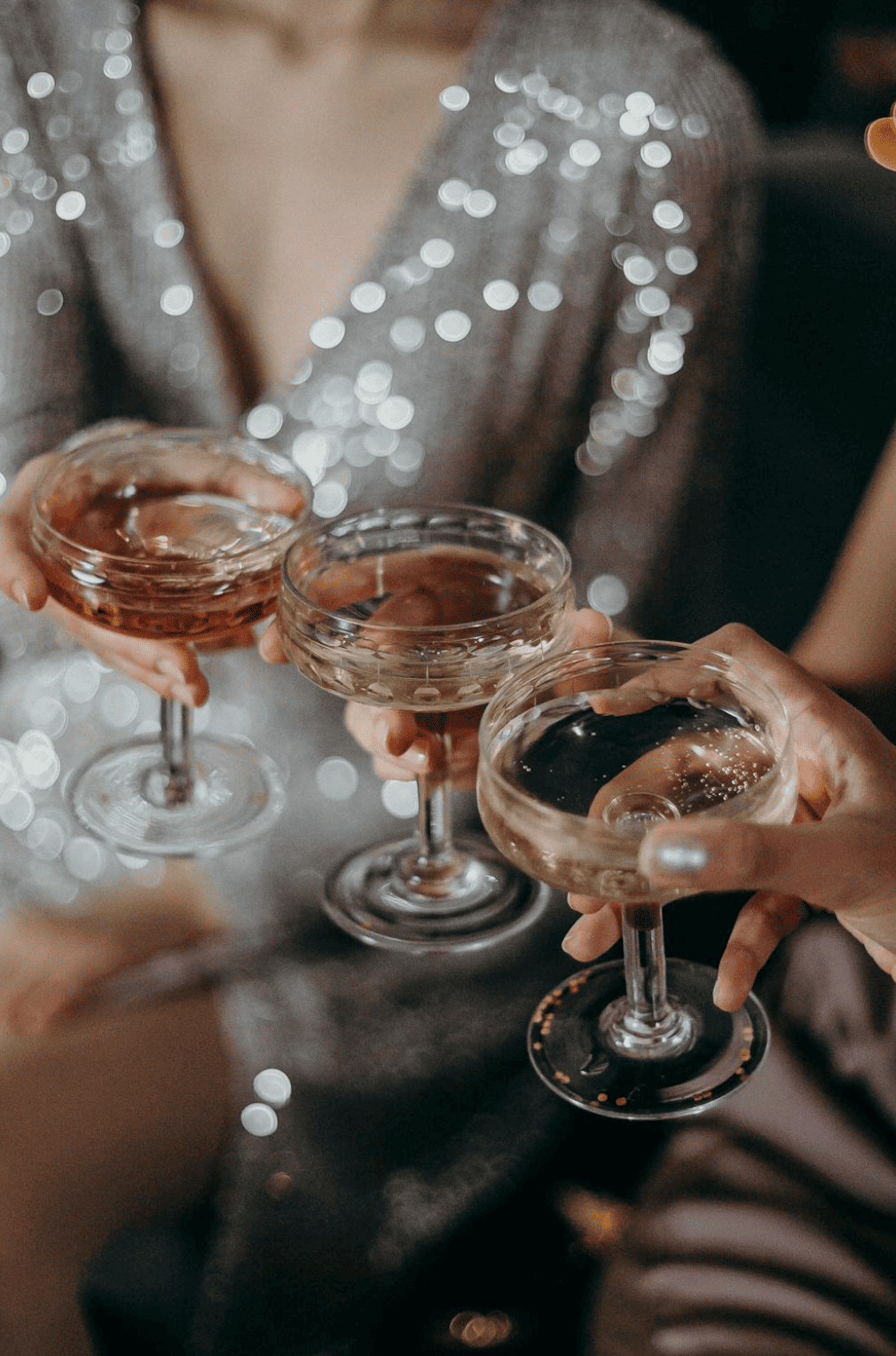 Groupe de filles trinquant avec des coupes de mousseux pendant une activité karaoké EVJF à Bruxelles, ambiance festive et joyeuse