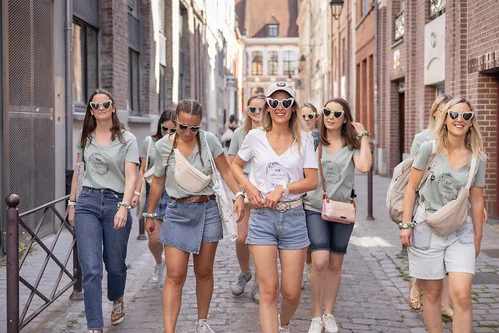 Groupe de femmes en tenue décontractée marchant ensemble dans une rue pavée