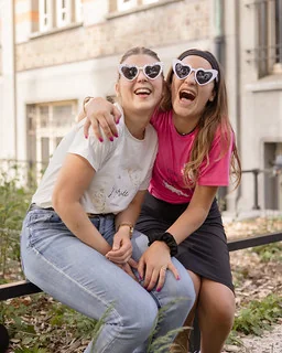 deux femmes portant des lunettes en forme de coeur rient lors d un clip video evjf a lille