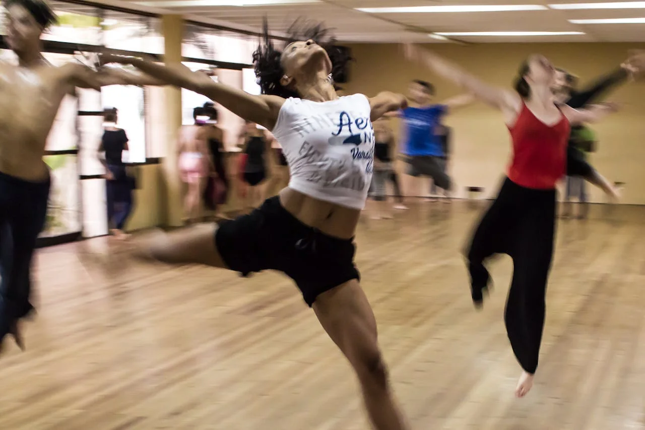 Danseuse en plein saut lors d’une chorégraphie dynamique pendant un cours de danse EVJF à Paris.