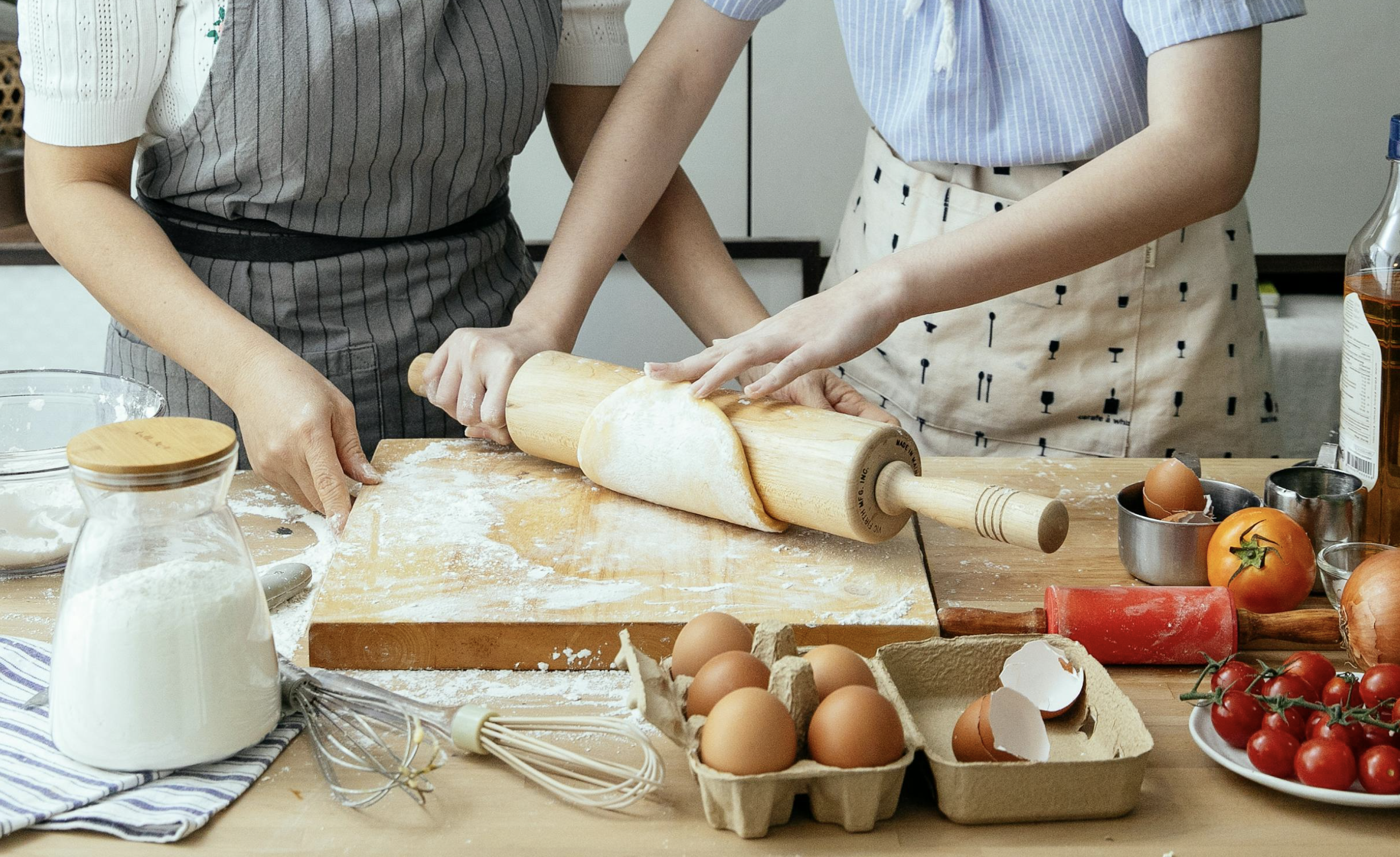Participant à un cours de cuisine EVJF à Bordeaux, en train de préparer un plat dans une ambiance chaleureuse et festive