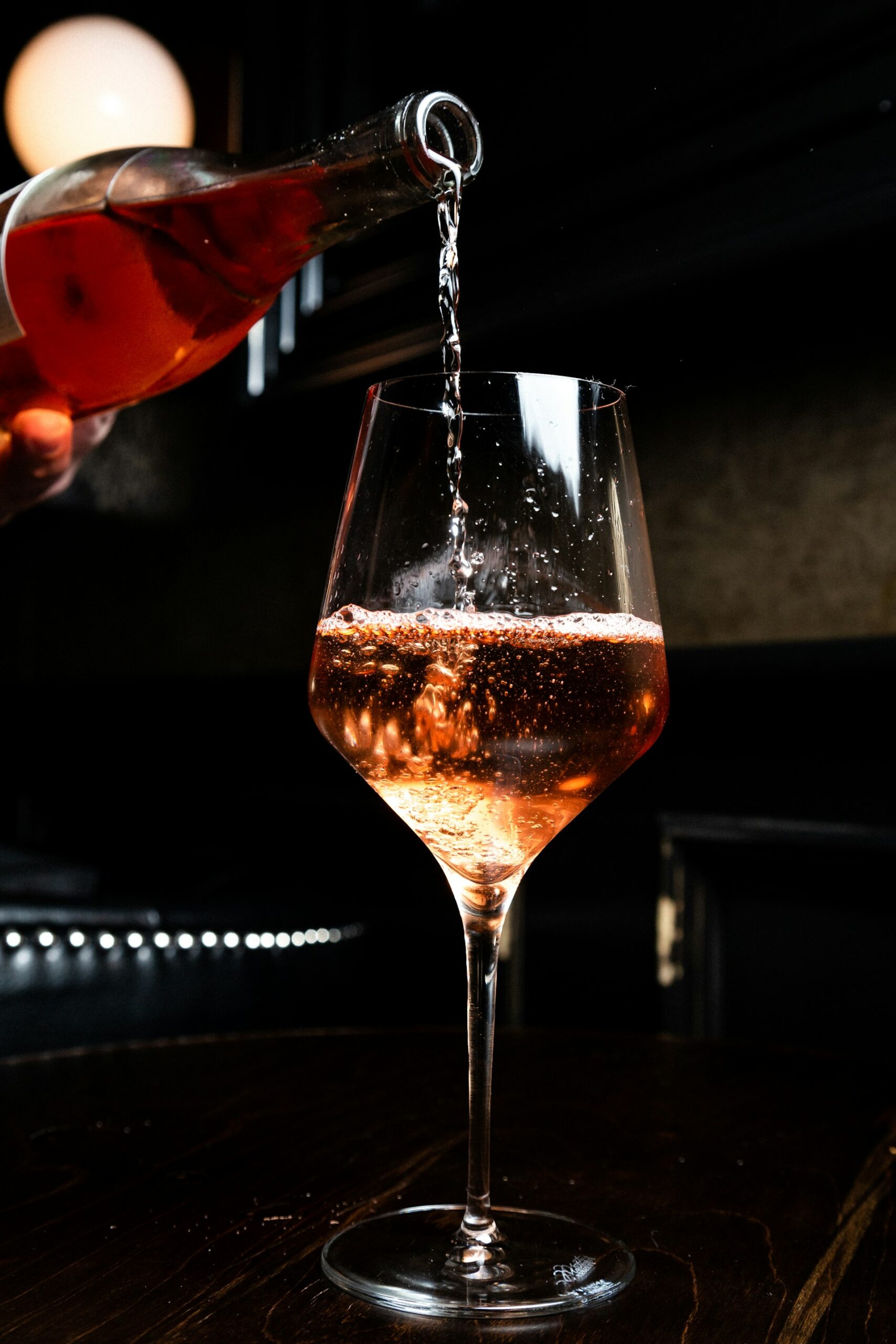 Sommelier en train de servir un rosé dans un verre à vin lors d'un EVJF à Paris.