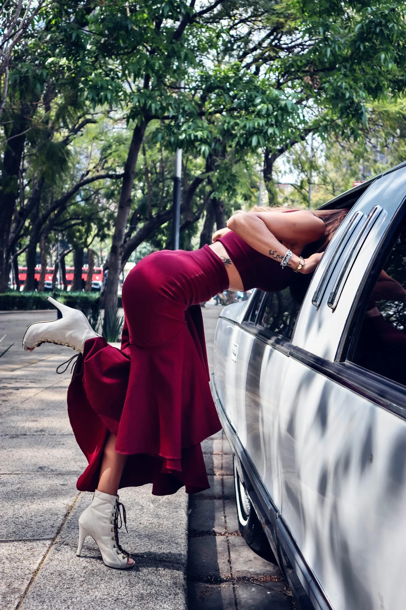 Femme en robe rouge se penchant dans une limousine à Reims