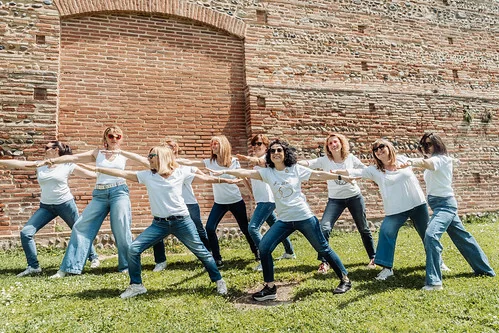 groupe de femmes en tenue décontractée réalisant une chorégraphie lors d’un evjf à toulouse devant un mur de briques rouges