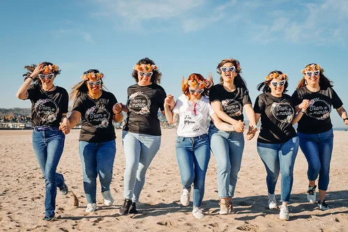 Groupe de jeunes femmes en t-shirts assortis courant sur la plage lors d’un Koh Bride, activité Koh Lanta spécial EVJF.