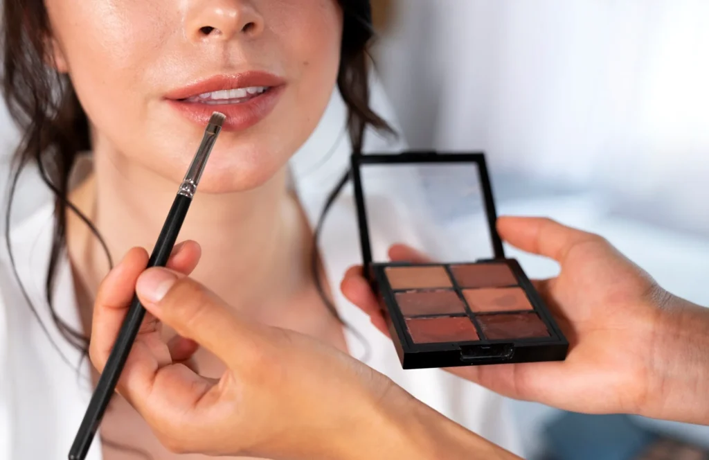 Gros plan sur une bouche en cours de maquillage professionnel pendant une séance mise en beauté EVJF.
