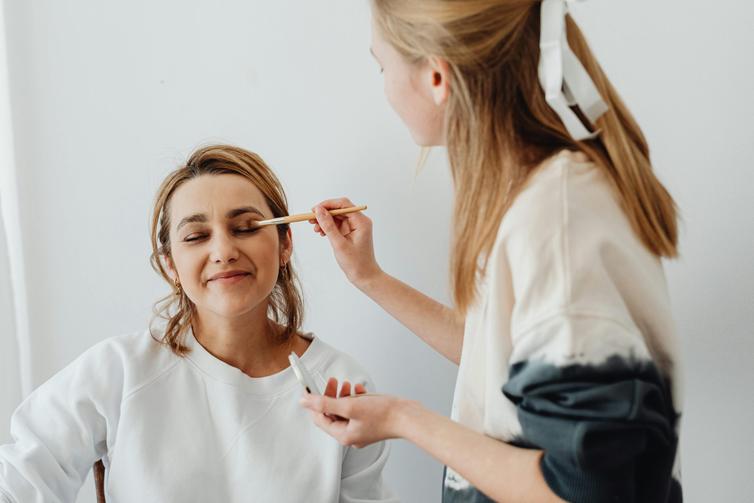 Future mariée maquillée par une professionnelle lors d’un atelier mise en beauté EVJF à Marseille, entourée de ses amies
