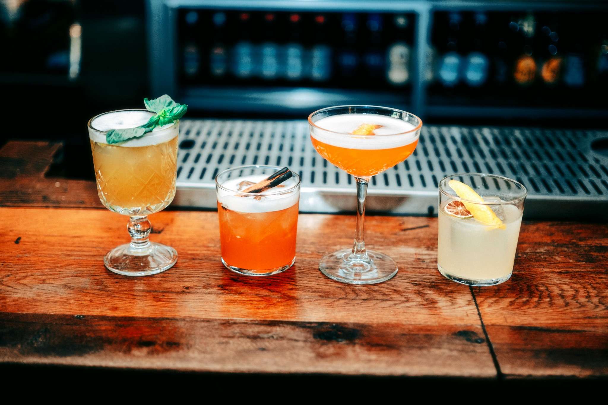 Cocktails colorés réalisés lors d’un atelier EVJF à Marseille, posés sur un comptoir en bois