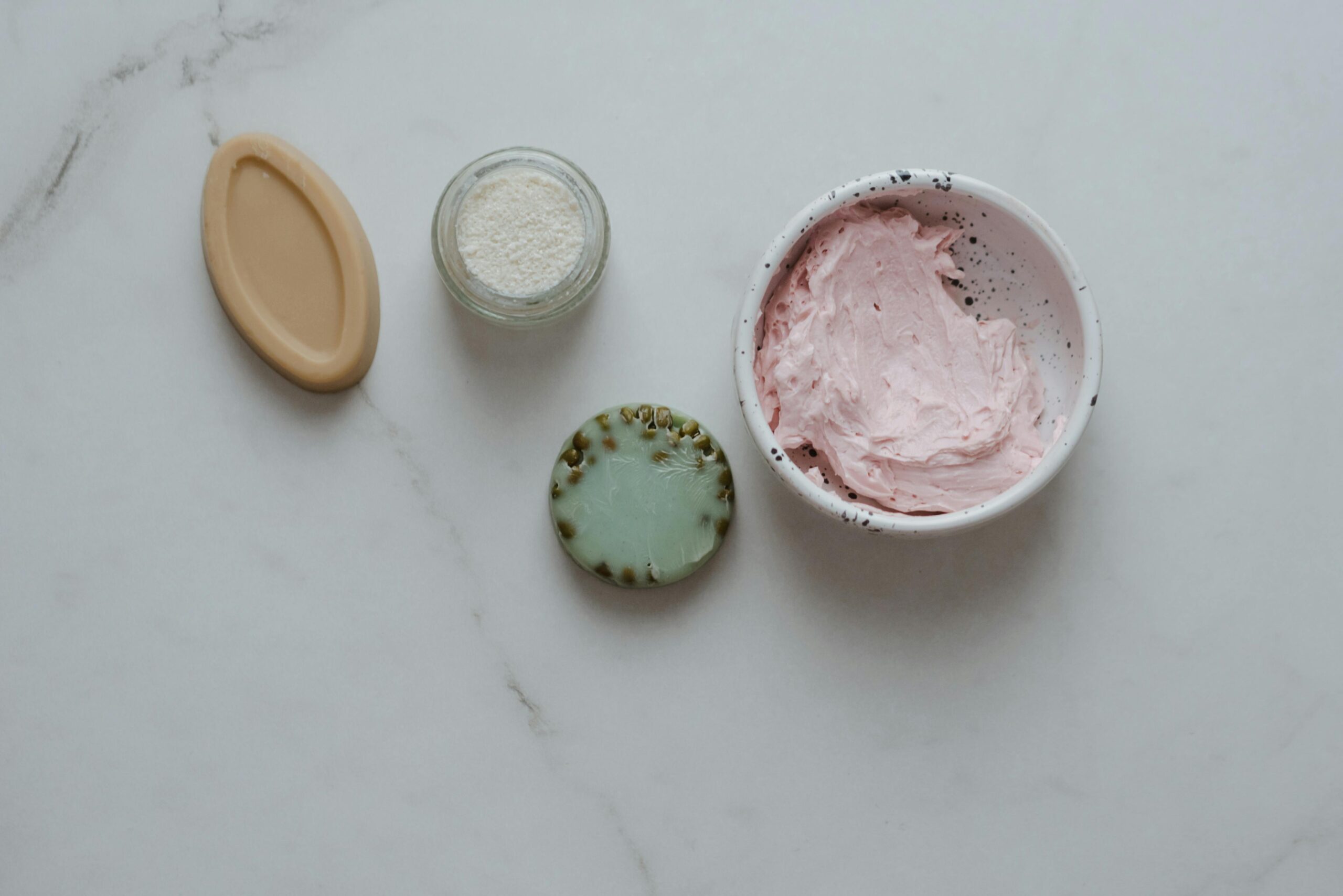 Produits cosmétiques DIY alignés sur une table lors d’un atelier cosmétique EVJF à Marseille : baumes, crèmes, huiles et bougies faits main