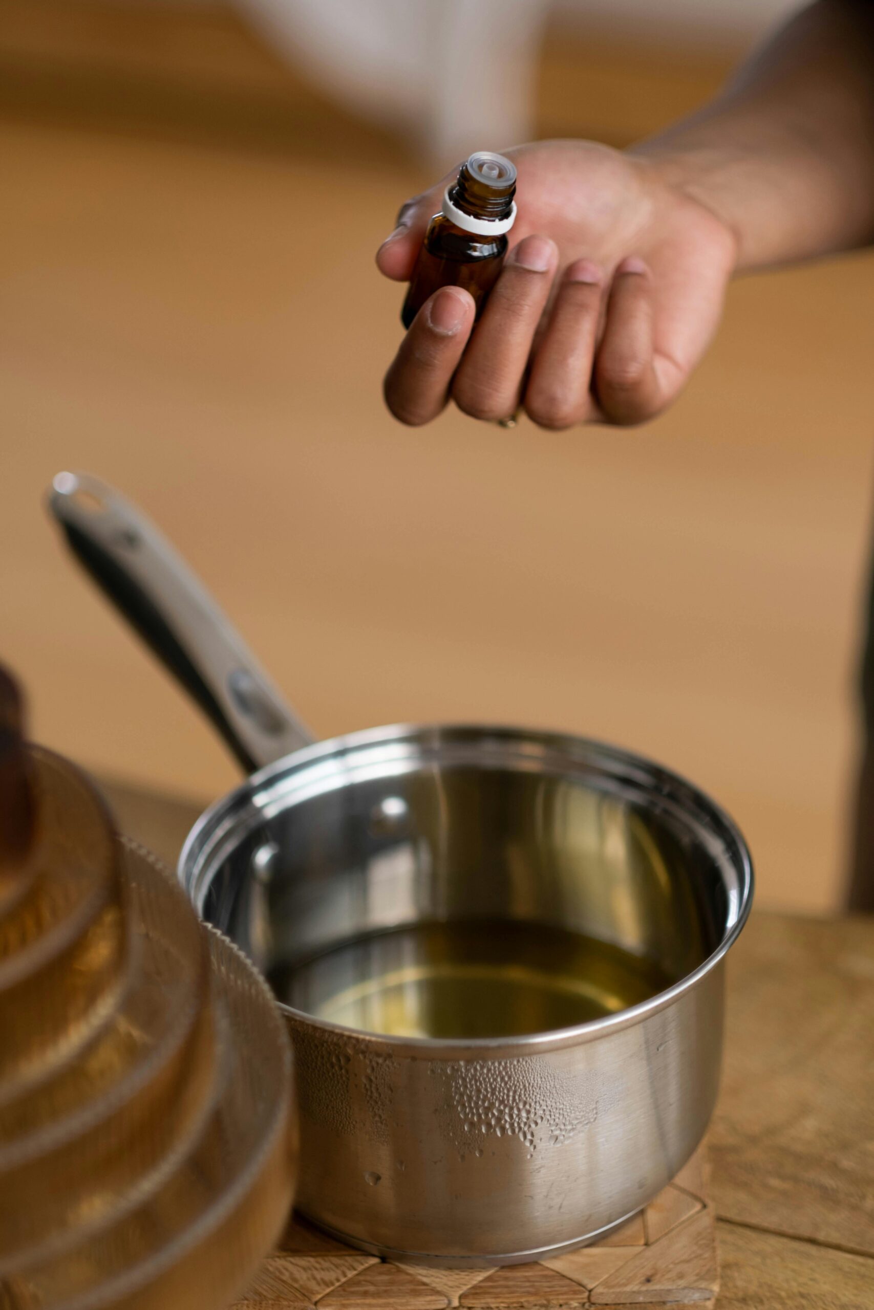 Huiles essentielles versées dans une casserole lors d’un atelier parfum d’ambiance EVJF à Marseille pour préparer une fragrance maison