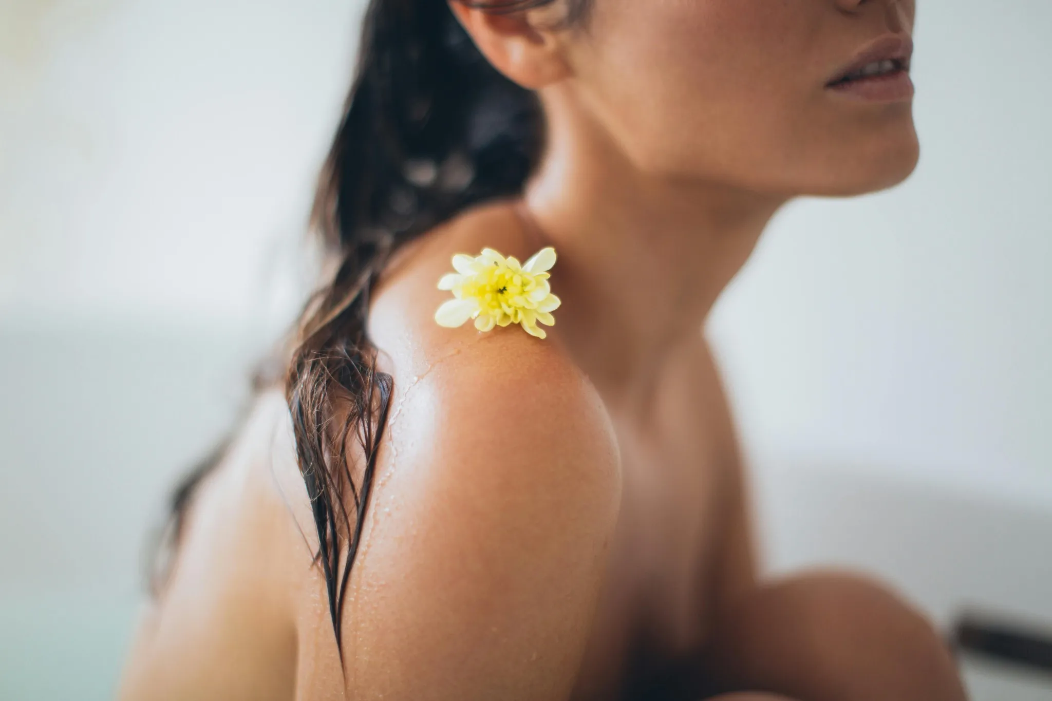 Épaule d’une femme avec une fleur jaune lors d’un EVJF spa au Touquet