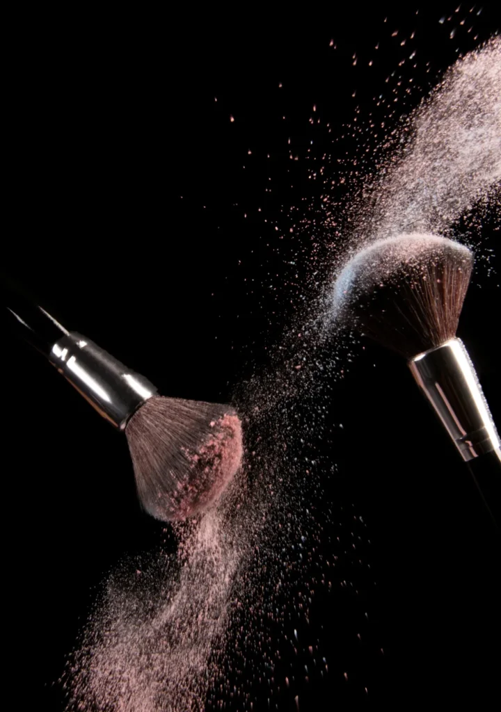 Gros plan de pinceaux appliquant de la poudre libre, maquillage professionnel à Aix-en-Provence.