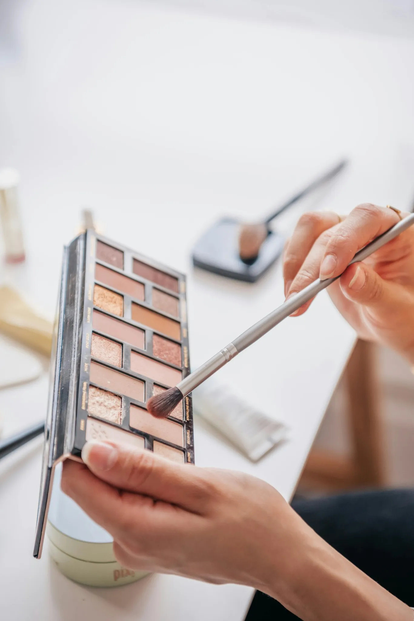 Utilisation d’un pinceau sur palette nude pendant une activité beauté EVJF à Aix-les-Bains