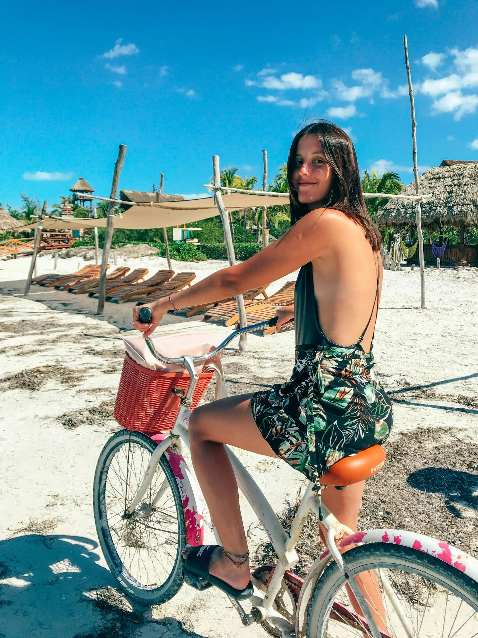 Femme à vélo sur la plage avec un panier rouge au Touquet