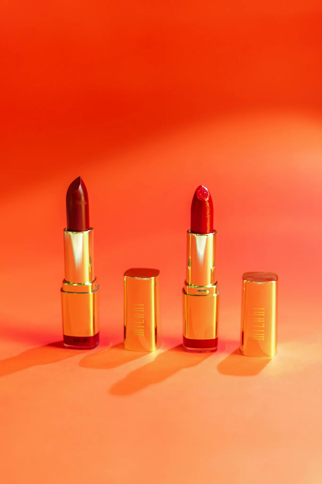 Trois rouges à lèvres rouges sur fond orange pour une activité maquillage à Tours