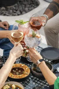 Gros plan de verres qui s’entrechoquent au-dessus de plats raffinés lors d’un EVJF à Lyon.