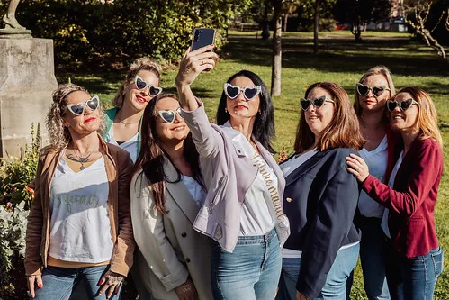 groupe de femmes en lunettes coeur prenant un selfie joyeux lors d’un evjf dans un parc a toulouse