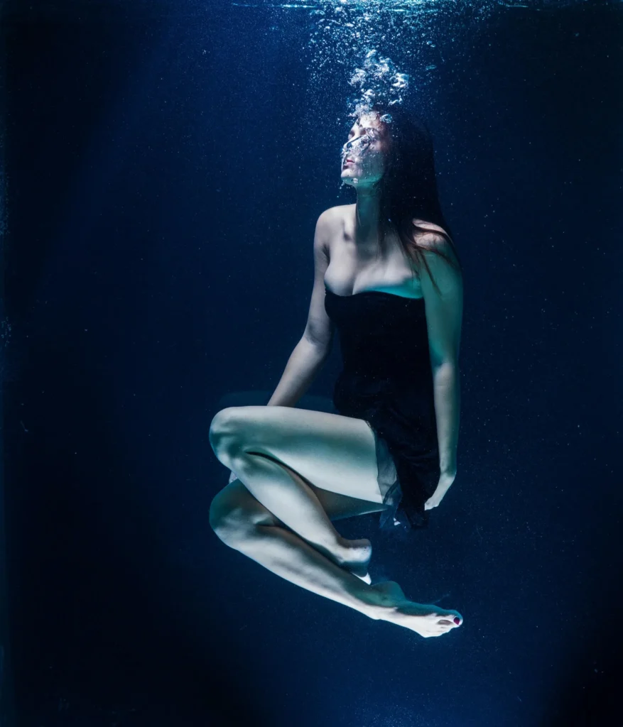 Femme en robe fluide capturée sous l’eau pendant un shooting underwater lors d’un EVJF en croisière à Marseille