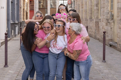 Groupe d’amies en tenue rose et lunettes cœur entourant la future mariée dans une rue pavée de Lille