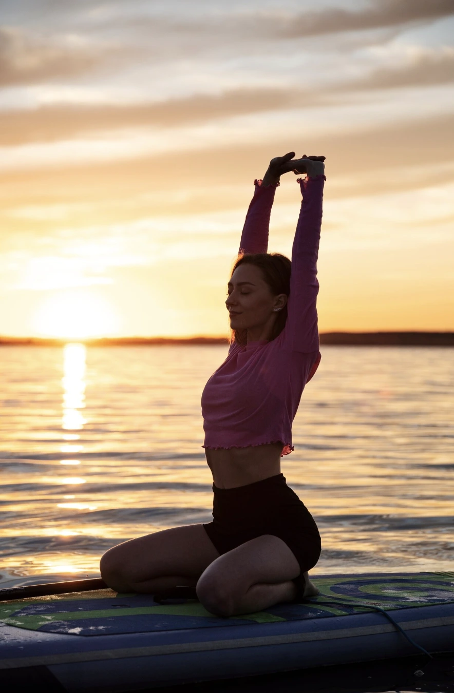 Femme en posture de yoga, équilibrée sur un paddle au milieu des eaux calmes du bassin d’Arcachon.