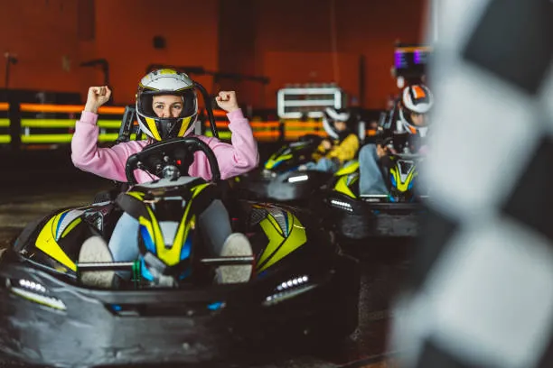 femme en karting levant les bras en signe de victoire lors d activites evjf sportives a nantes