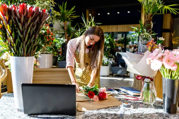 Femme réalisant un bouquet de fleurs lors d’un atelier floral 
