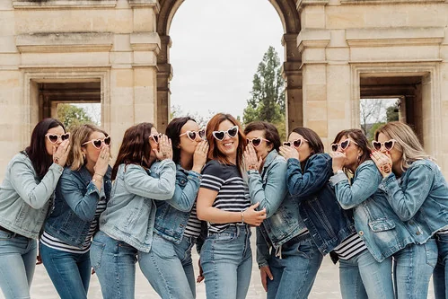 groupe de femmes en jean et lunettes coeur celebrant un brunch evjf a bordeaux devant un monument