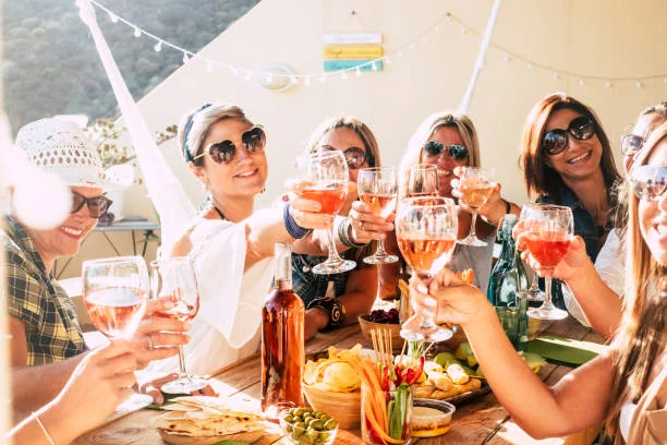 Groupe de femmes souriantes trinquant au vin rosé autour d’une grande table conviviale lors d’un brunch EVJF à Nantes.