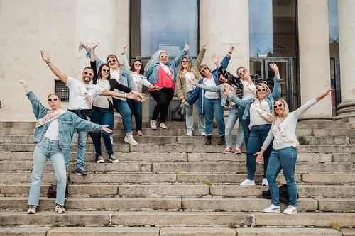 groupe de femmes en jean et accessoires evjf pose avec energie sur des escaliers