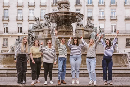 groupe de femmes en mariniere leve les bras devant une fontaine lors d une chasse au tresor evjf a nantes