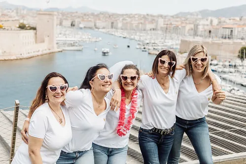 cinq femmes souriantes en lunettes coeur lors d un evjf à marseille avec vue sur le vieux port