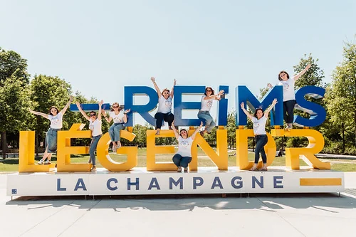 groupe de femmes saute et pose devant l enseigne reims legende la champagne lors d une chasse au tresor evjf a reims