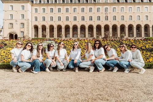 groupe de femmes en jeans et t shirt blanc pose devant un batiment historique fleuri lors d une chasse au tresor evjf a rennes