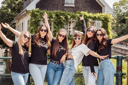 groupe de femmes en tee shirts noirs et jeans posant ensemble
